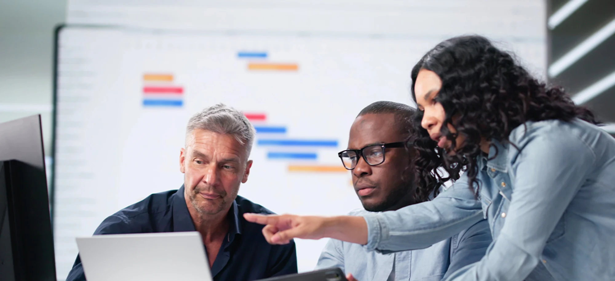 A diverse tech team collaborating at a computer