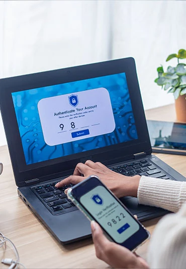 A woman at a laptop entering a login authentication code