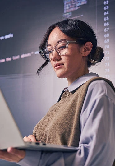 A female tech professional working on a laptop