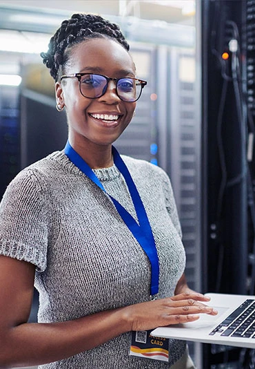 A young female tech professional holding a laptop