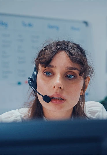 Woman with a headset taking a call at a help desk